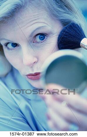 Stock Photo - Close-up of a woman applying make-up. Fotosearch