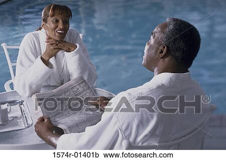 Couple sitting beside a swimming pool View Large Photo Image Stock Image - Couple sitting beside a swimming pool. Fotosearch