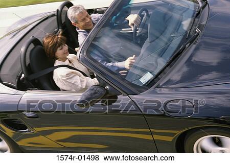 Stock Photo - Couple sitting in a convertible car. Fotosearch