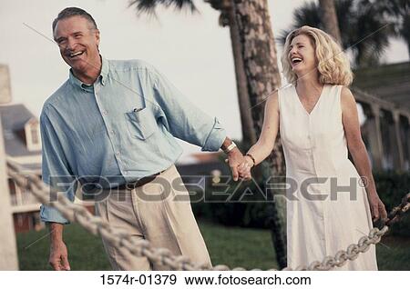 Stock Photo - Couple walking holding hands. Fotosearch