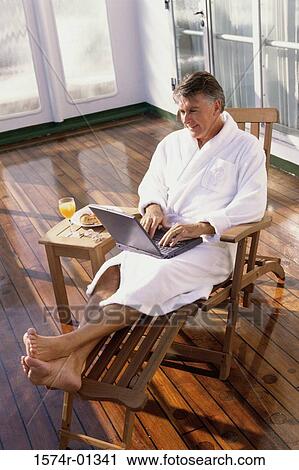 High angle view of a man in a bathrobe working on a laptop View Large Photo Image Stock Image - High angle view of a man in a bathrobe working on a laptop. Fotosearch