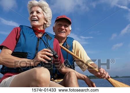Low angle view of a senior couple in a row boat View Large Photo Image Stock Image - Low angle view of a senior couple in a row boat. Fotosearch