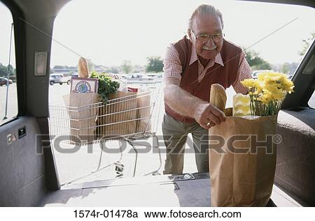 Man taking a grocery bag from the back of a car View Large Photo Image Stock Image - Man taking a grocery bag from the back of a car. Fotosearch