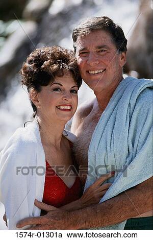 Stock Image - Portrait of a couple holding each other smiling. Fotosearch