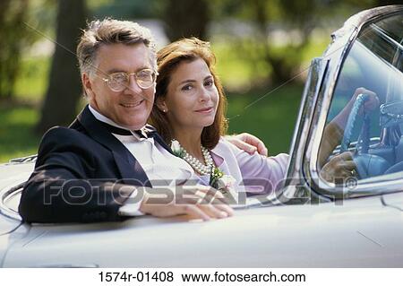 Stock Photo - Portrait of a couple sitting in a convertible car. Fotosearch