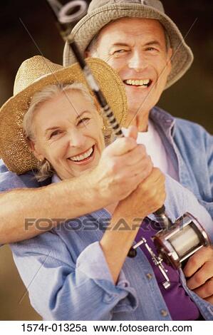 Portrait of a senior couple holding a fishing rod View Large Photo Image Stock Image - Portrait of a senior couple holding a fishing rod. Fotosearch