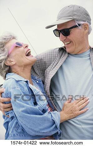 Stock Image - Portrait of a senior couple holding each other laughing. Fotosearch
