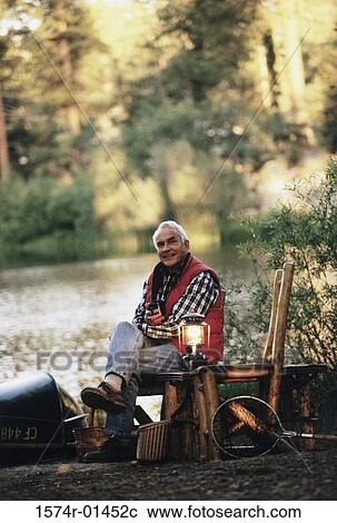 Portrait of a senior man sitting outdoors on a chair View Large Photo Image Stock Image - Portrait of a senior man sitting outdoors on a chair. Fotosearch