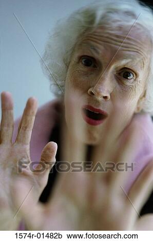 Stock Image - Portrait of a senior woman holding her hands out. Fotosearch
