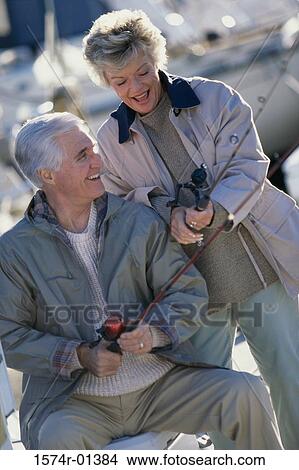 Senior couple fishing holding fishing rods View Large Photo Image Picture - Senior couple fishing holding fishing rods. Fotosearch
