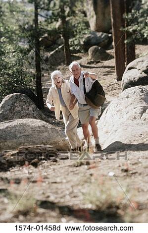 Stock Image - Senior couple hiking in the woods. Fotosearch