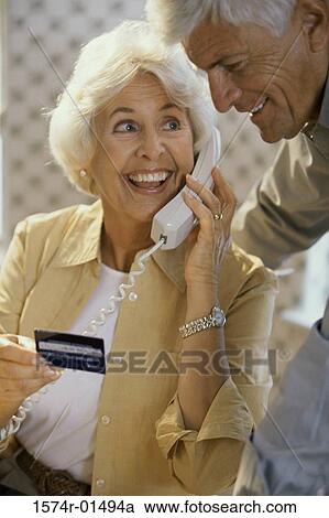 Stock Image - Senior couple holding a credit card. Fotosearch
