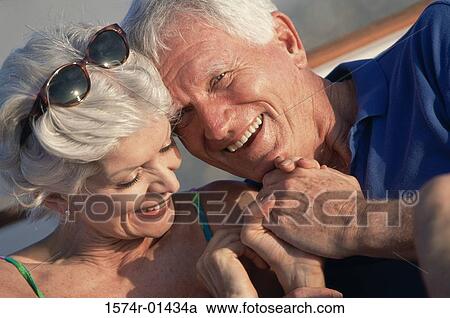 Stock Image - Senior couple holding hands. Fotosearch
