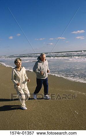 Stock Photo - Senior couple jogging at the beach. Fotosearch