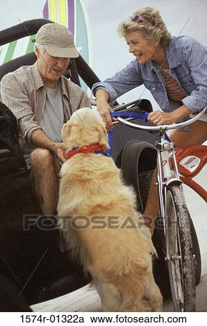 Stock Image - Senior couple petting a dog. Fotosearch