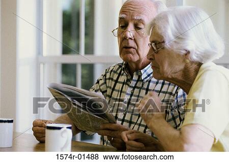 Senior couple reading a newspaper together View Large Photo Image Stock Photo - Senior couple reading a newspaper together. Fotosearch