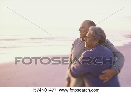 Stock Photo - Senior couple standing together at the beach. Fotosearch