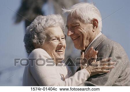Senior couple standing together laughing View Large Photo Image Stock Image - Senior couple standing together laughing. Fotosearch