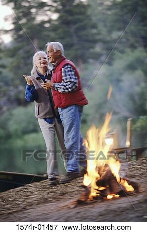 Senior couple together near a campfire in the woods View Large Photo Image Stock Photo - Senior couple together near a campfire in the woods. Fotosearch