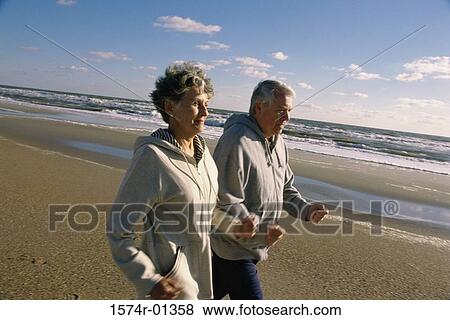 Stock Photo - Senior couple walking at the beach. Fotosearch