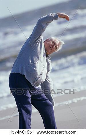 Stock Image - Senior man exercising at the beach. Fotosearch