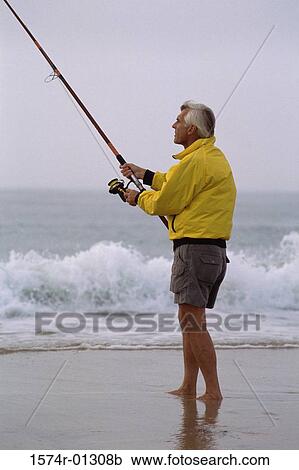 Stock Image - Senior man fishing on the beach. Fotosearch