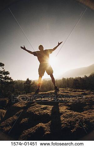 Silhouette of a senior man standing outdoors with his arms outstretched View Large Photo Image Stock Image - Silhouette of a senior man standing outdoors with his arms outstretched. Fotosearch