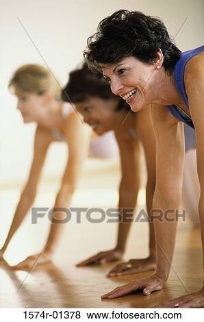 Stock Photo - Three women exercising with their hands resting on the floor. Fotosearch