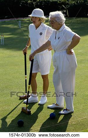 Two senior women standing on a lawn holding croquet mallets View Large Photo Image Stock Image - Two senior women standing on a lawn holding croquet mallets. Fotosearch