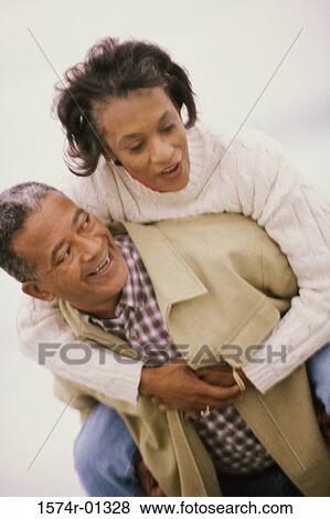 Woman riding piggyback on a man View Large Photo Image Stock Photo - Woman riding piggyback on a man. Fotosearch