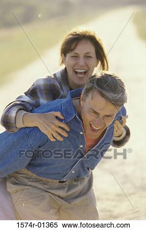 Stock Photography - Woman riding piggyback on a man. Fotosearch
