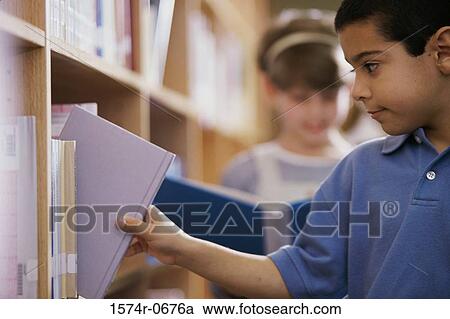 Boy taking a book from a shelf View Large Photo Image Stock Image - Boy taking a book from a shelf. Fotosearch