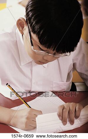 Boy writing on sheets of paper View Large Photo Image Stock Photo - Boy writing on sheets of paper. Fotosearch