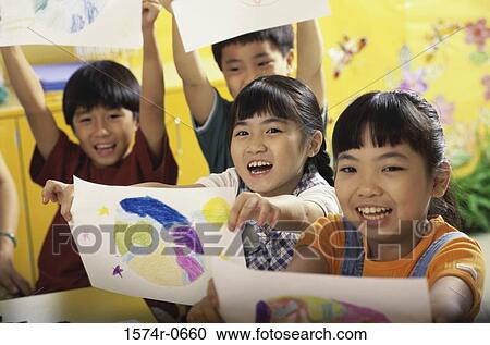 Children holding drawing sheets in a class View Large Photo Image Stock Image - Children holding drawing sheets in a class. Fotosearch