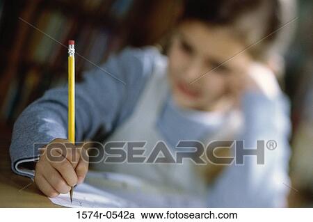 Close-up of a girl sitting and writing with a pencil View Large Photo Image Stock Image - Close-up of a girl sitting and writing with a pencil. Fotosearch