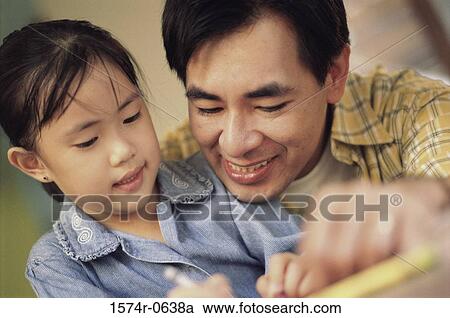 Stock Image - Father helping his daughter study. Fotosearch