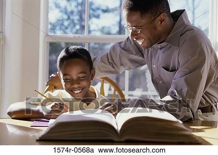 Stock Image - Father helping his son with homework. Fotosearch