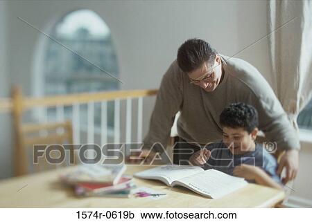 Stock Image - Father helping his son with homework. Fotosearch