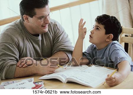 Stock Image - Father helping his son with homework. Fotosearch