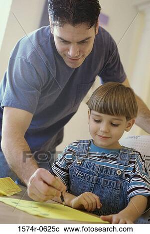 Stock Image - Father helping his son with homework. Fotosearch