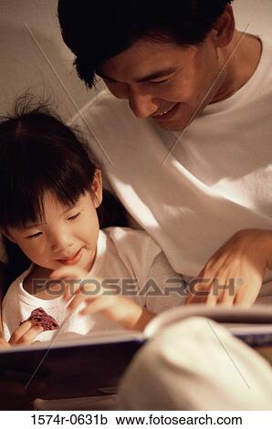 Stock Image - Father helping his son with homework. Fotosearch