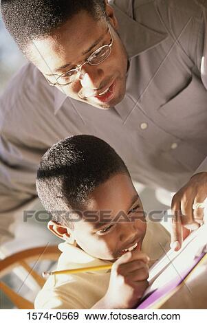 Stock Photo - Father helping his son with homework. Fotosearch