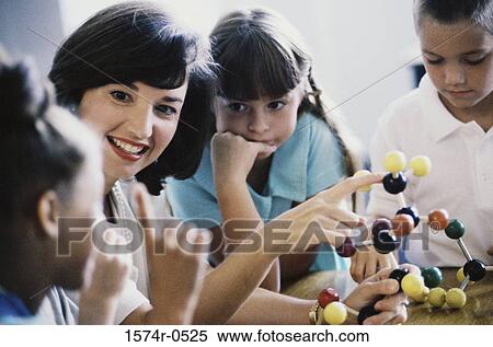 Female teacher showing her students a model of a molecular structure View Large Photo Image Stock Photography - Female teacher showing her students a model of a molecular structure. Fotosearch