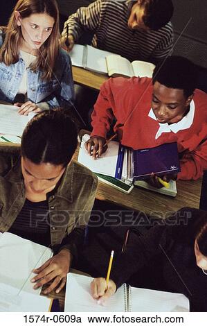 Stock Image - High angle view of teenage students taking a test in class. Fotosearch