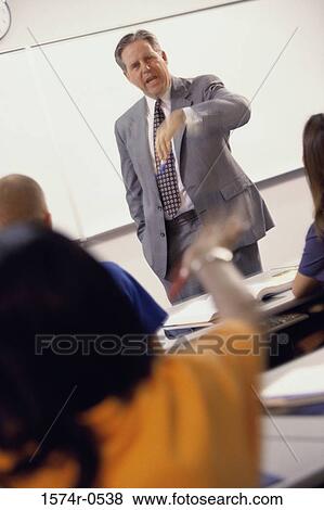 Male teacher standing in front of a classroom View Large Photo Image Stock Photo - Male teacher standing in front of a classroom. Fotosearch