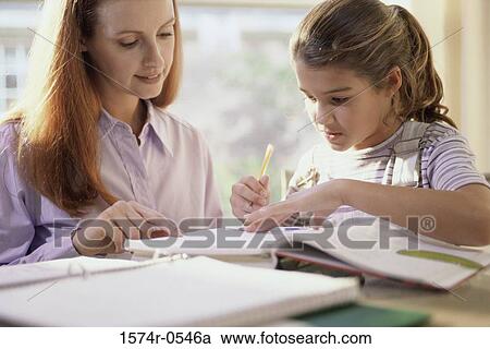 Stock Image - Mother and her daughter reading a book. Fotosearch