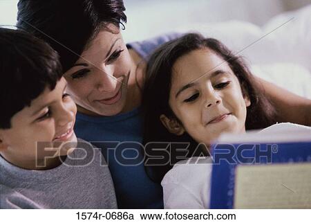 Mother and her two children reading a book View Large Photo Image Stock Image - Mother and her two children reading a book. Fotosearch