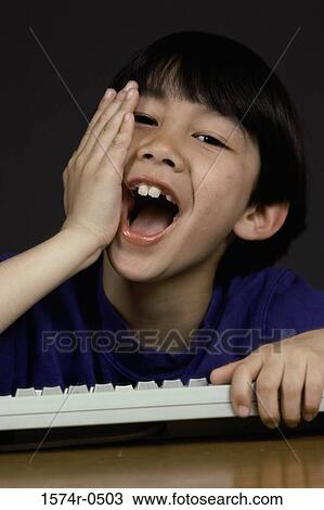 Portrait of a boy holding a computer keyboard laughing View Large Photo Image Stock Image - Portrait of a boy holding a computer keyboard laughing. Fotosearch