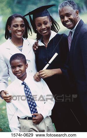 Stock Photo - Portrait of a female graduate student standing with her parents and brother. Fotosearch