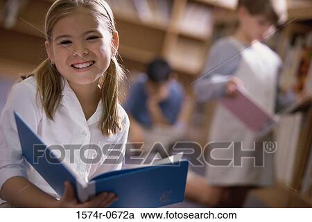 Portrait of a girl holding a book smiling View Large Photo Image Stock Image - Portrait of a girl holding a book smiling. Fotosearch